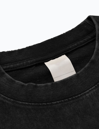 Detailansicht des Materials des Oversized Acid-Wash-T-Shirts in Schwarz im Halsbereich.