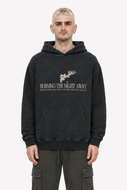 Mann trägt einen acid wash oversized hoodie mit dem Aufdruck "BURNING THE NIGHT AWAY" in coolen Streetwear-Style.